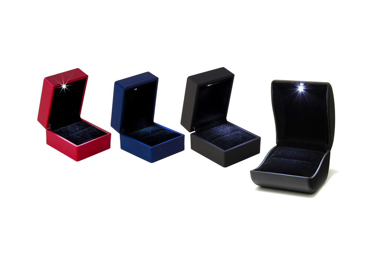 Four varied jewelry boxes in red, blue, and black, perfect for showcasing rings and small treasures.